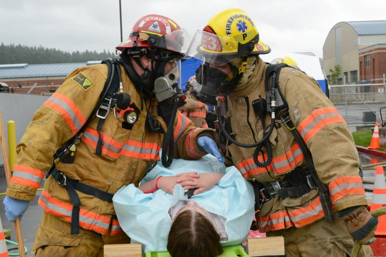 two firefighters rescue a girl who is on a table