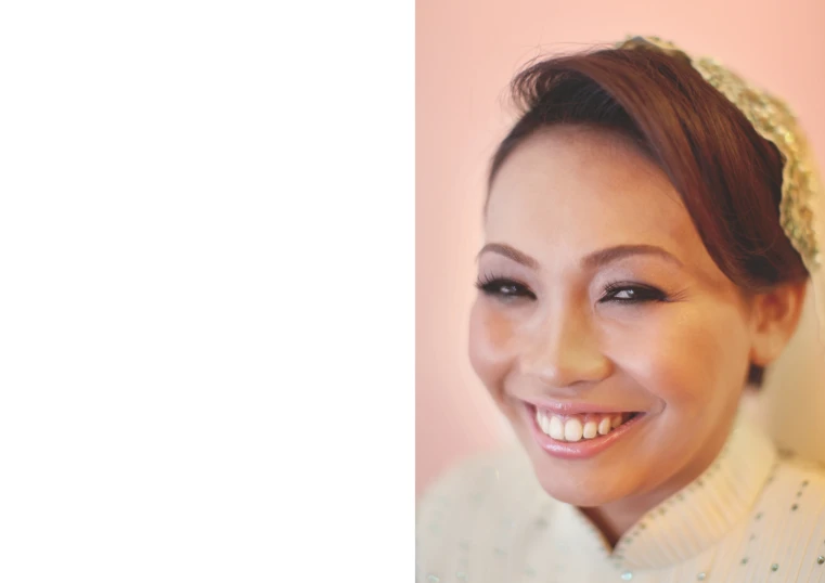 woman smiling with a white shirt on and blue eyeliners