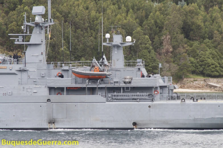 a grey large boat traveling through a body of water