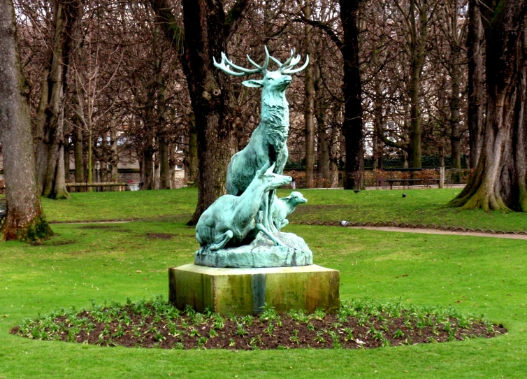 statue in a park surrounded by green grass