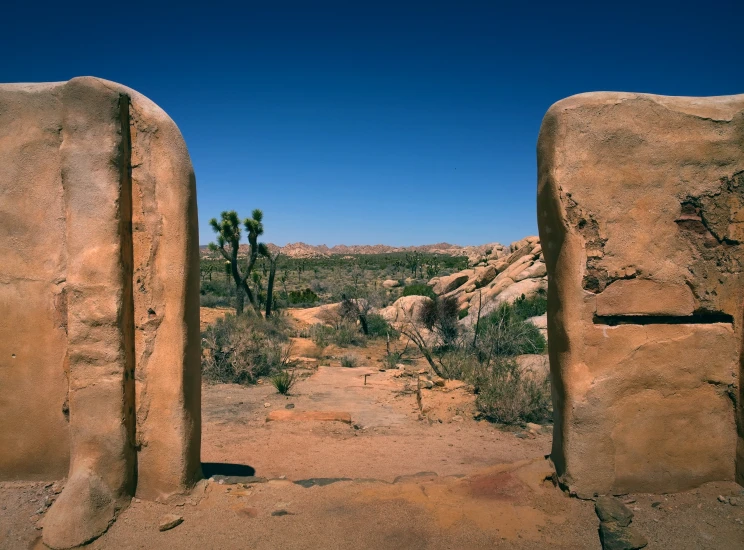 two large rocks near each other in front of an arch