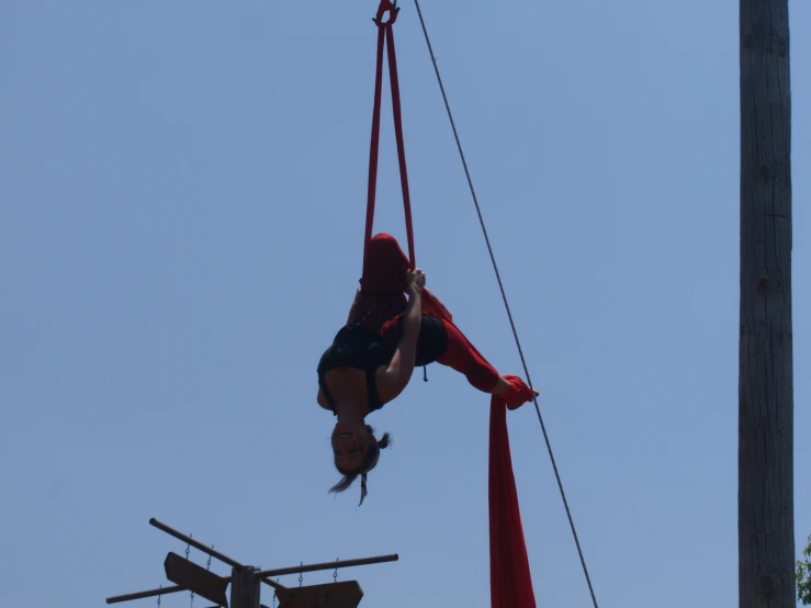 a person riding a zipline on top of a wooden pole