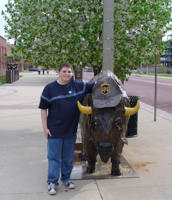 a man stands next to a statue of an bull