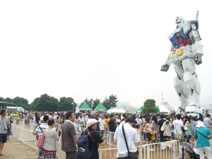 a giant robot sculpture is suspended above the crowd