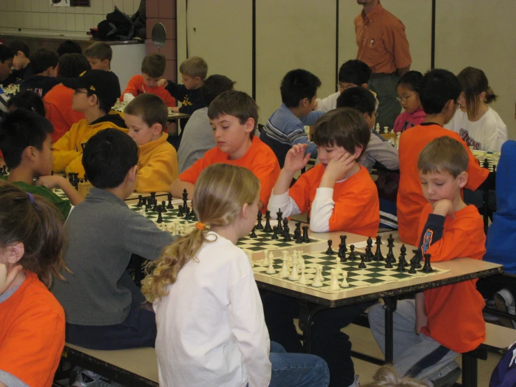 a room full of boys and girls playing chess