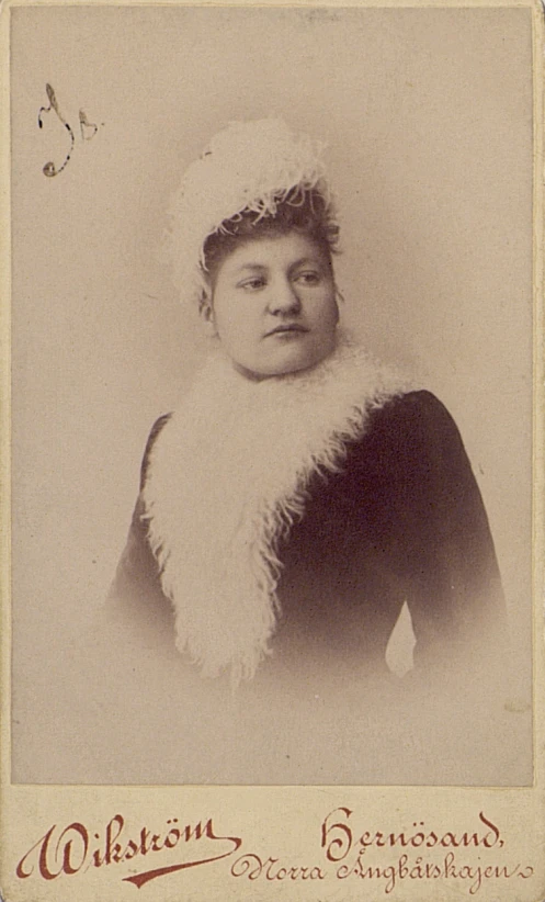 a woman with a fur collar and a long white scarf