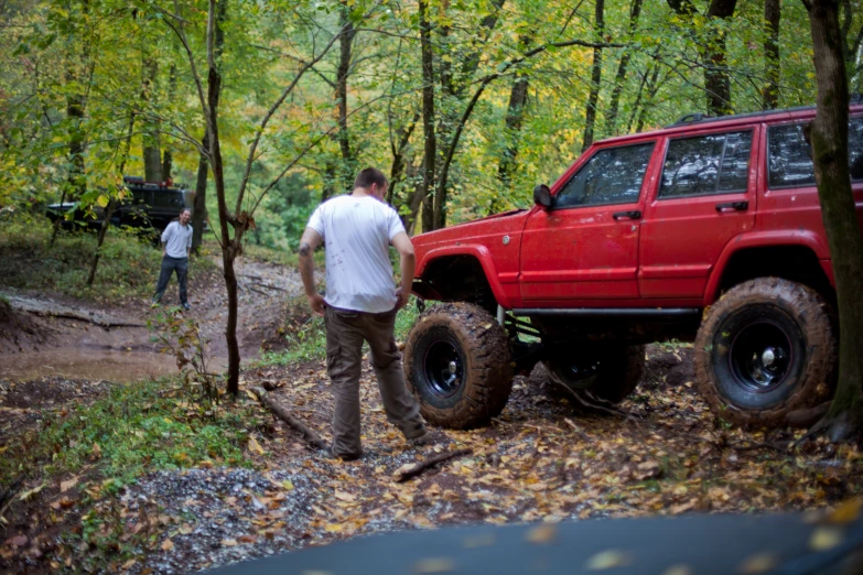 a man is pulling his truck through the woods