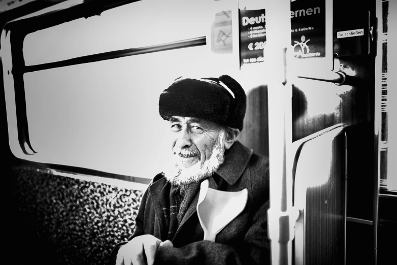 man wearing beanie looking out the door of subway train