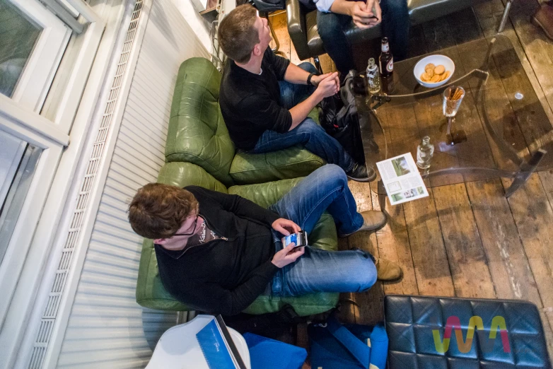 three people sitting on chairs while taking pictures