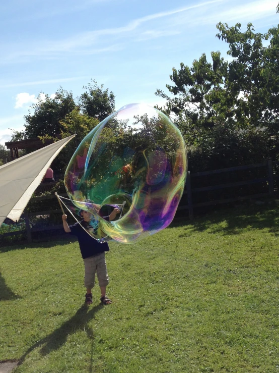 person in yard with bubble bubble bubble kite