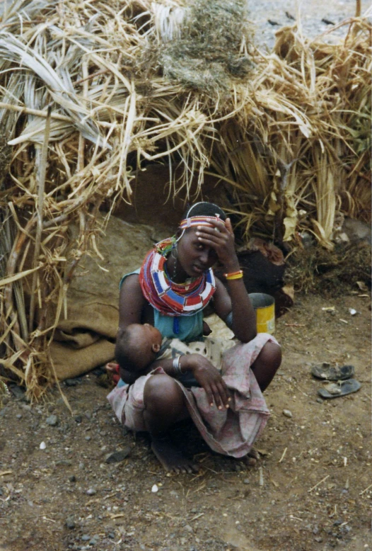 a person sitting on the ground covered in straw