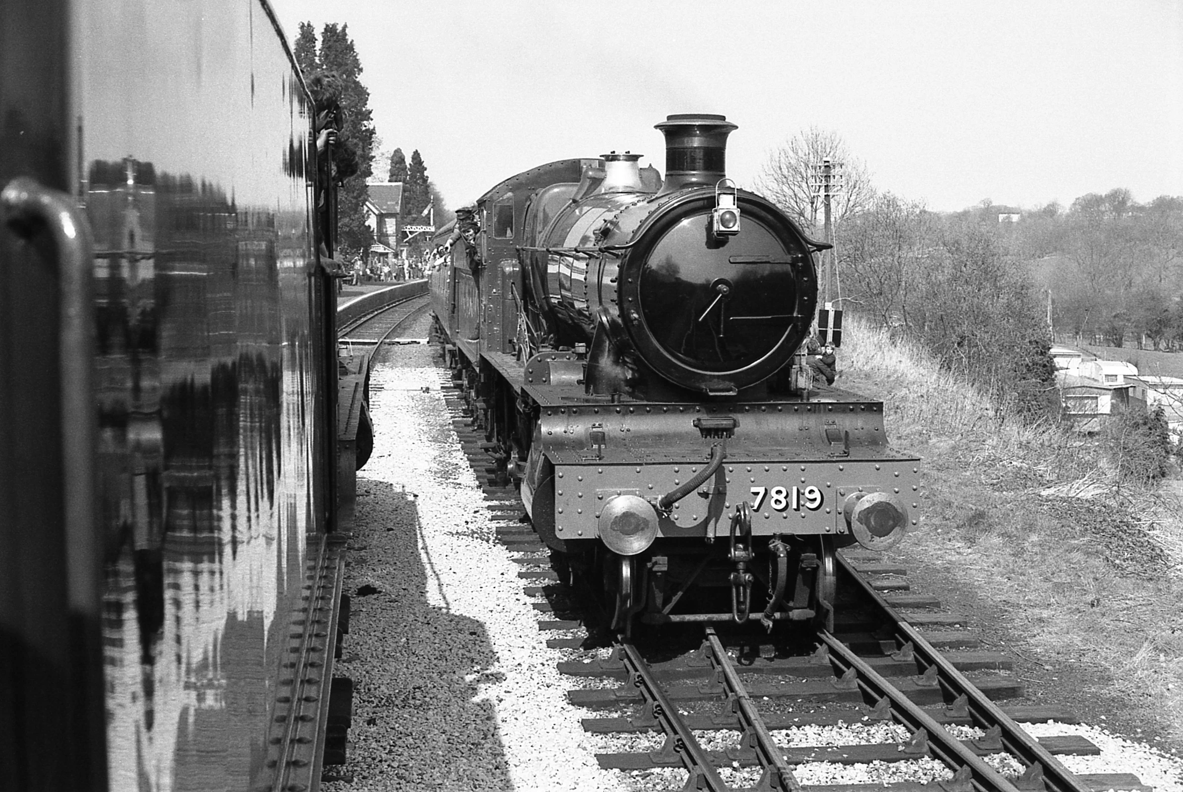 a train on tracks and people standing next to it