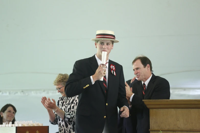 a person with a hat and tie holding soing in his hand