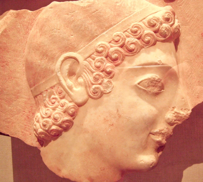 a plaster mask of a woman wearing an intricately detailed crown