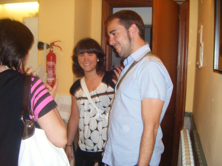 two people standing talking and laughing in the hallway