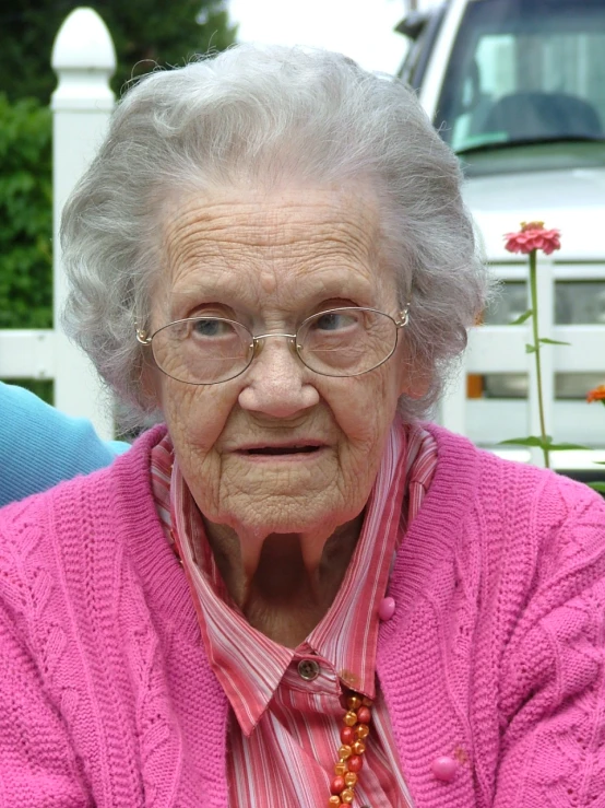 an elderly woman wearing glasses looking to her right