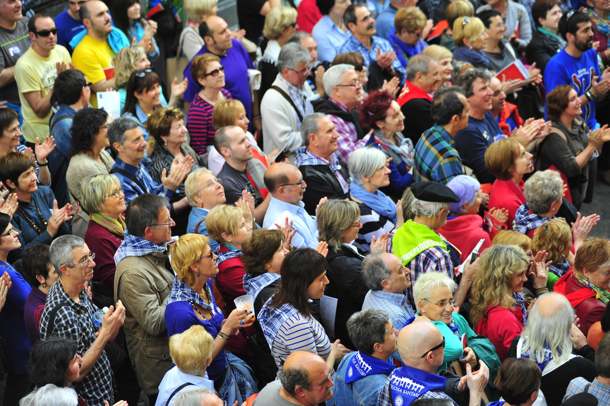 a crowd of people are standing together with their hands together