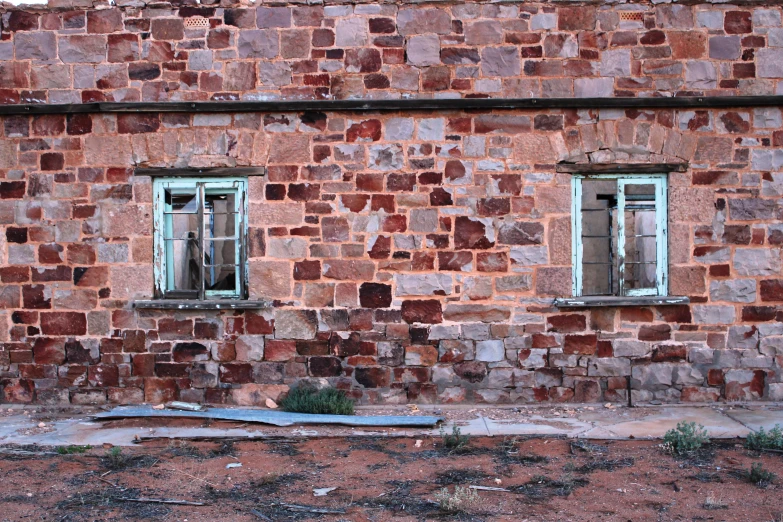 an old red brick building with two windows