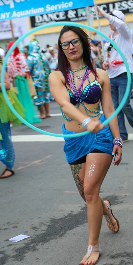 a woman in a colorful bathing suit dancing through a hoop