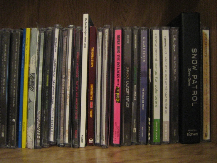 various cd's on a wooden shelf together