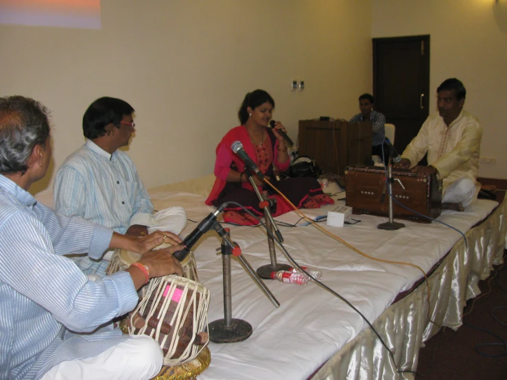 a group of people seated around a table playing instruments