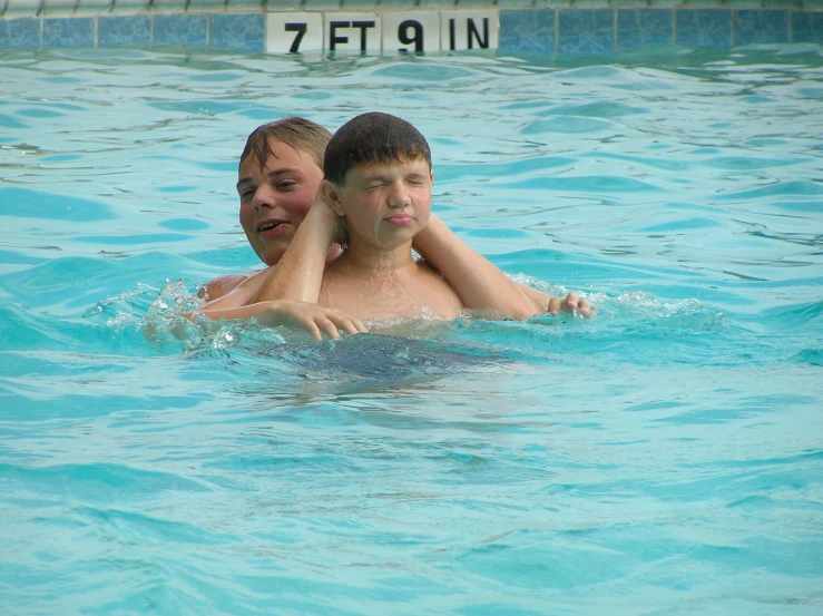 man and child swimming in a pool with no one around