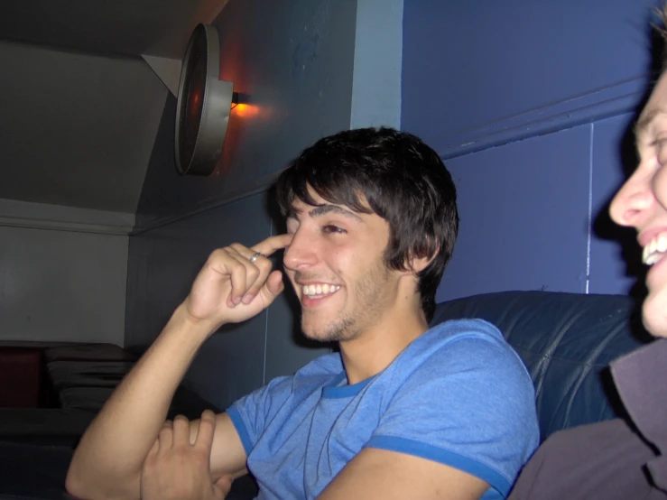 two men sitting together and smiling at the same time