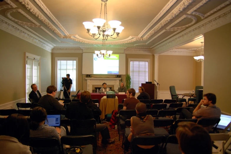 many people in chairs in front of a podium