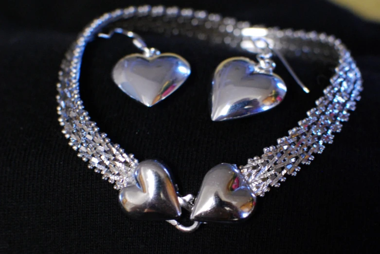 a heart shaped necklace with a chain link and matching pair of earrings