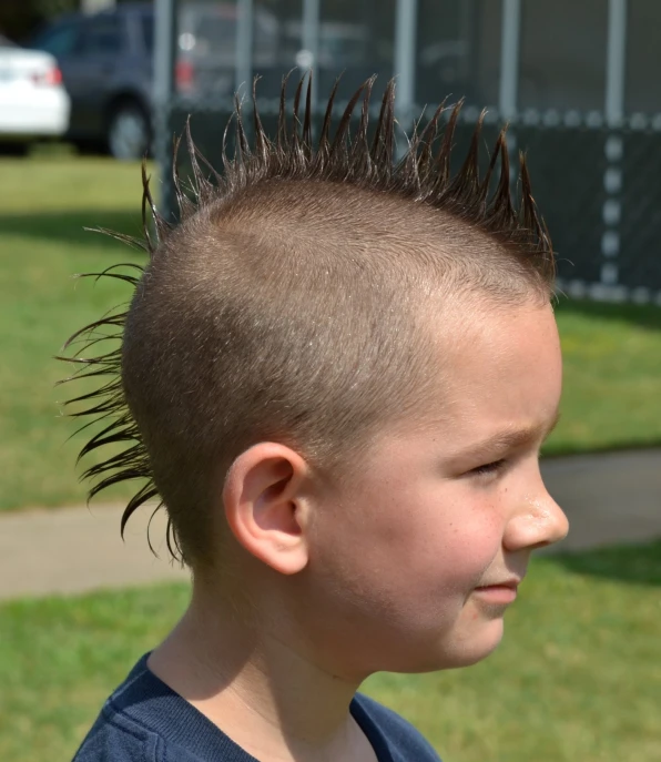 a boy with spiked hair looking at soing