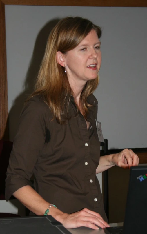 a woman standing with her hands on a laptop