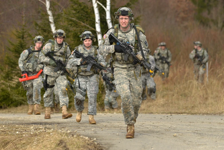 the military men are running on the road together