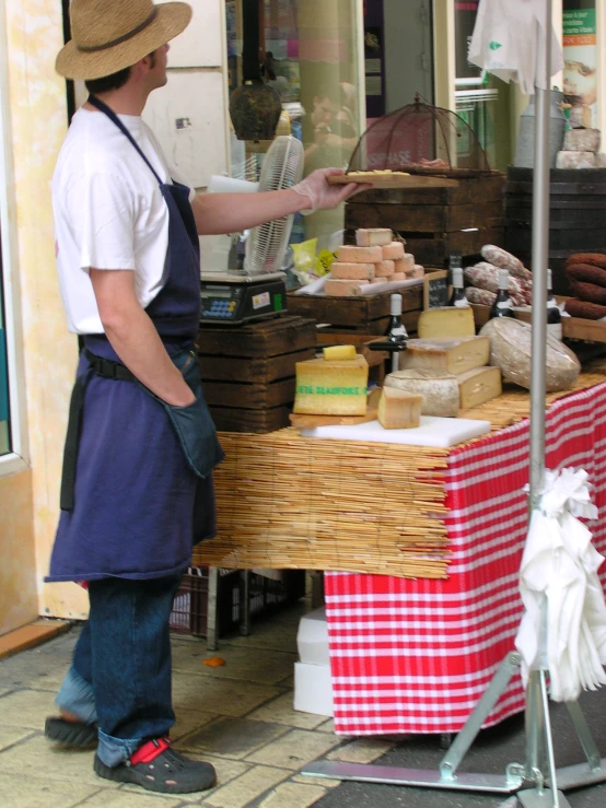 an older man standing in front of a store selling baked goods