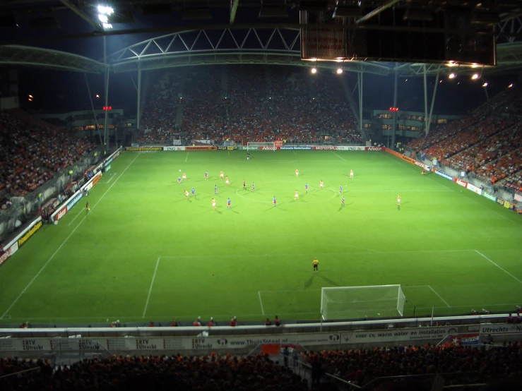 a stadium filled with people and people standing on top of a soccer field