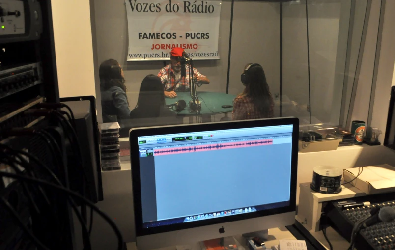 a desk with a computer monitor and sound equipment