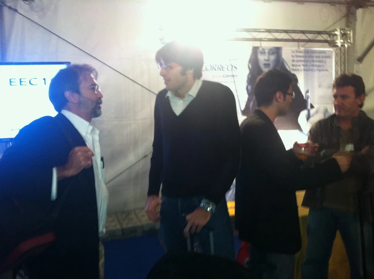 a group of men are standing inside a tent talking