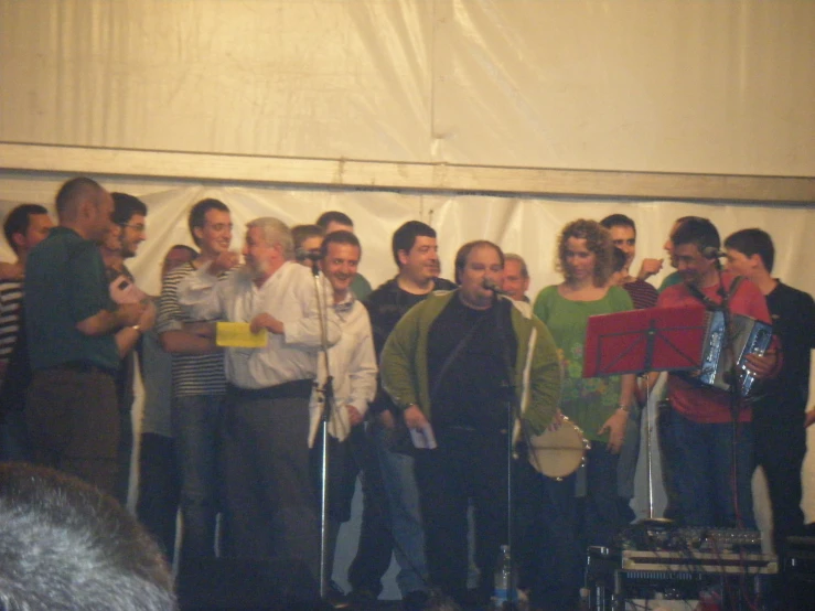 people gathered together talking in front of white fabric curtains