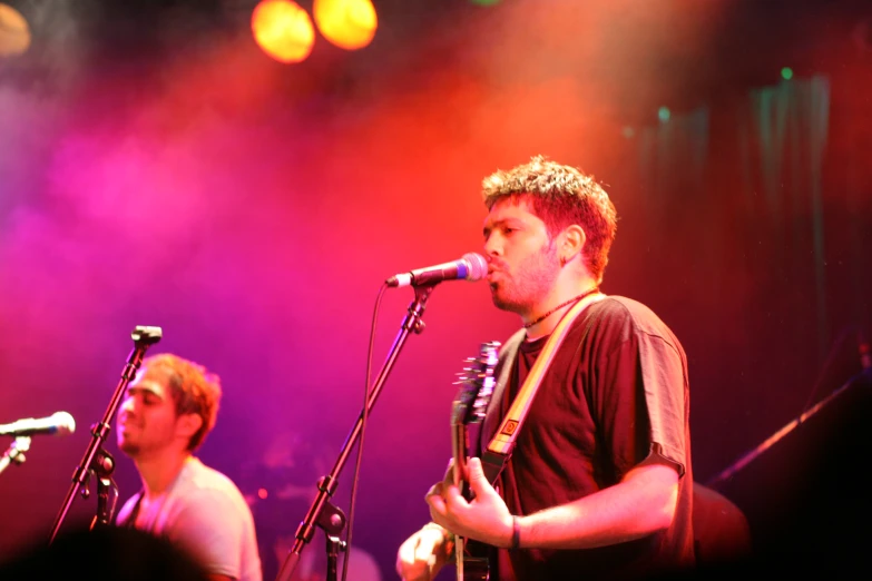 some men playing instruments in front of a microphone