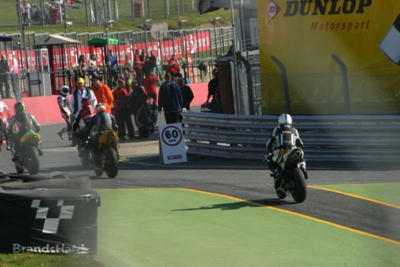 a number of motorcyclists riding down a race track