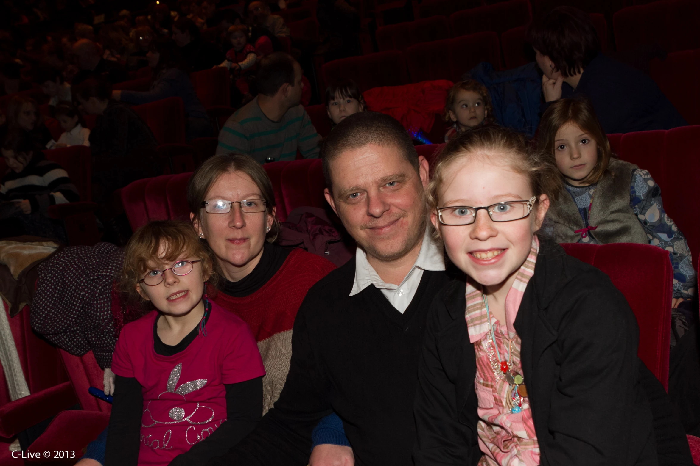 a man and a girl in seats with the men and woman behind them