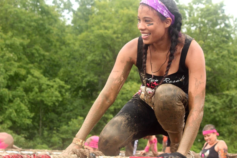 woman wearing mud boots and a pink bandana is squatting down