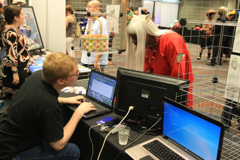 a person sitting in front of two laptop computers