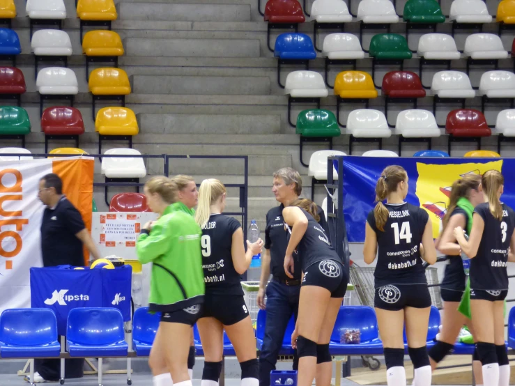 several female volleyball players and coach at a game