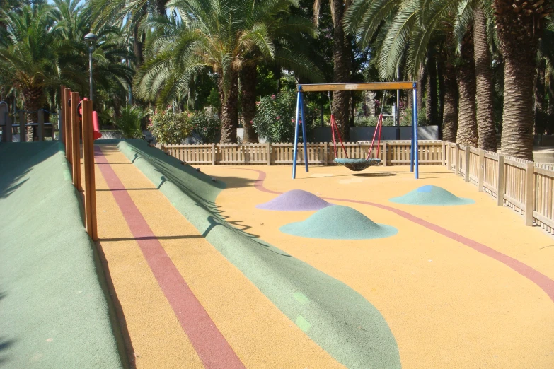 children play area at a city park with palm trees
