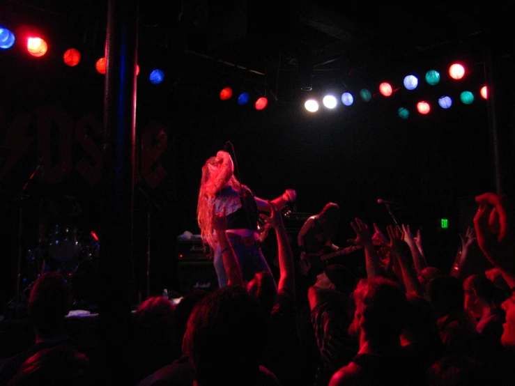 woman singing in front of a crowd at a concert