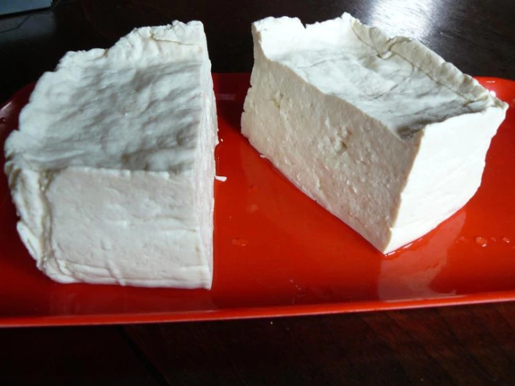 a red plate topped with a square white cake