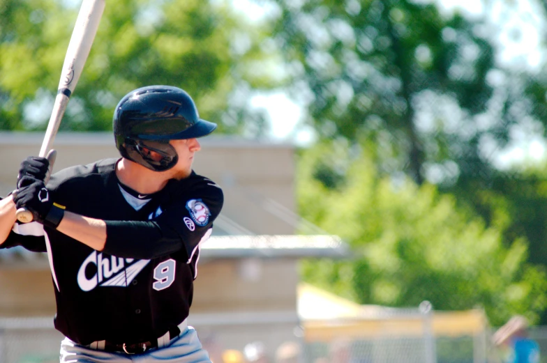 a man in a black jersey is playing baseball