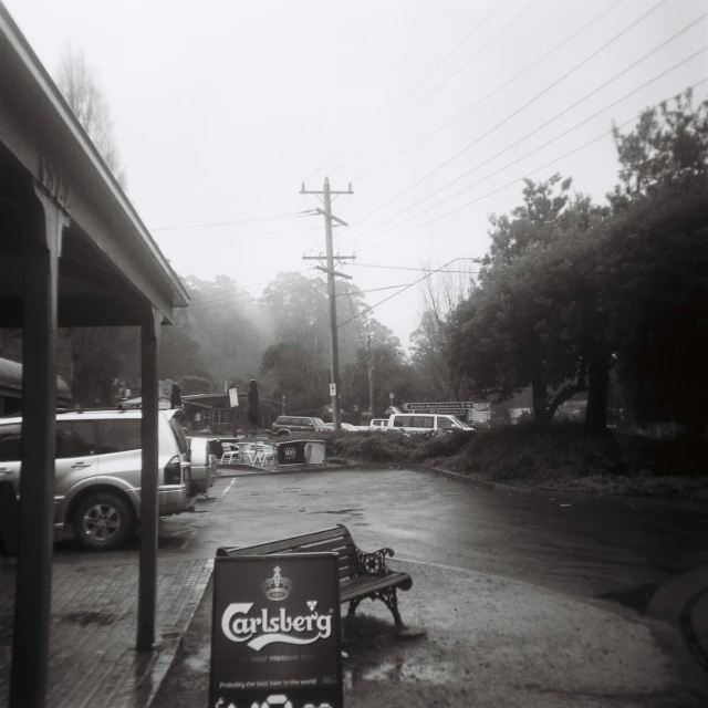 the black and white po shows an old bench and gas station