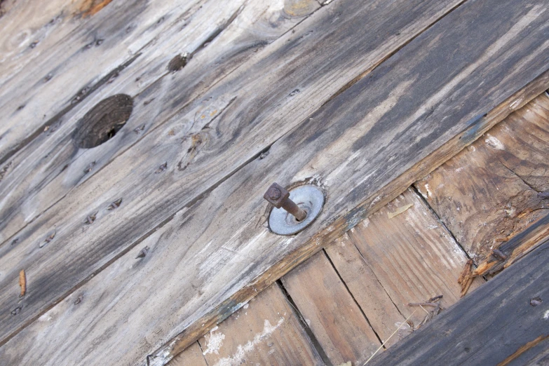 a piece of wood with a rusted padlock and an iron key