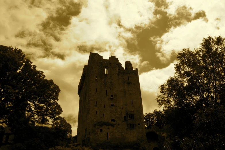 the tall tower stands against the cloudy sky